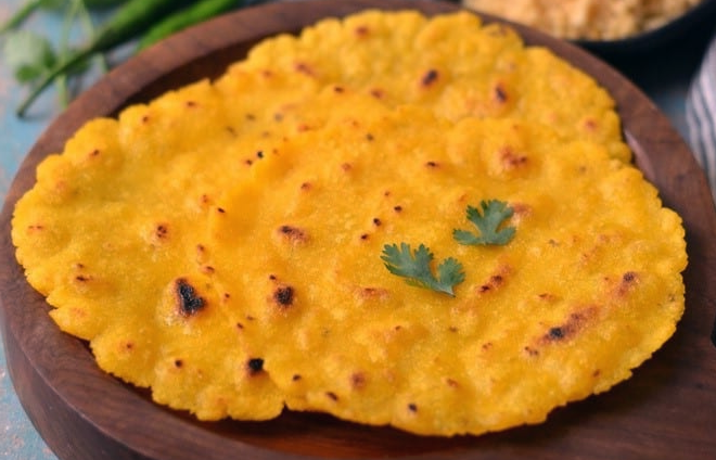 three makki di roti flatbreads on a wooden chopping board