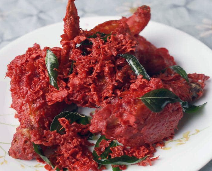 Ayam Goreng, Malaysian fried chicken garnished with fried curry leaves on a plate
