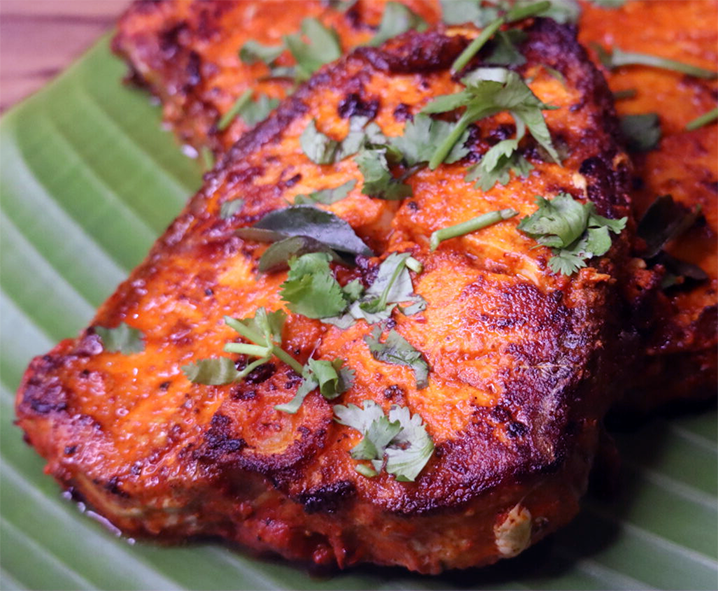 masala fried fish served on a banana leaf