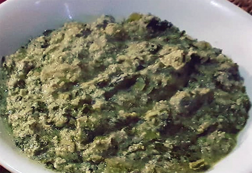 Matapa, prawn and cassava leaf stew in a coconut and peanut base served mounded in a bowl