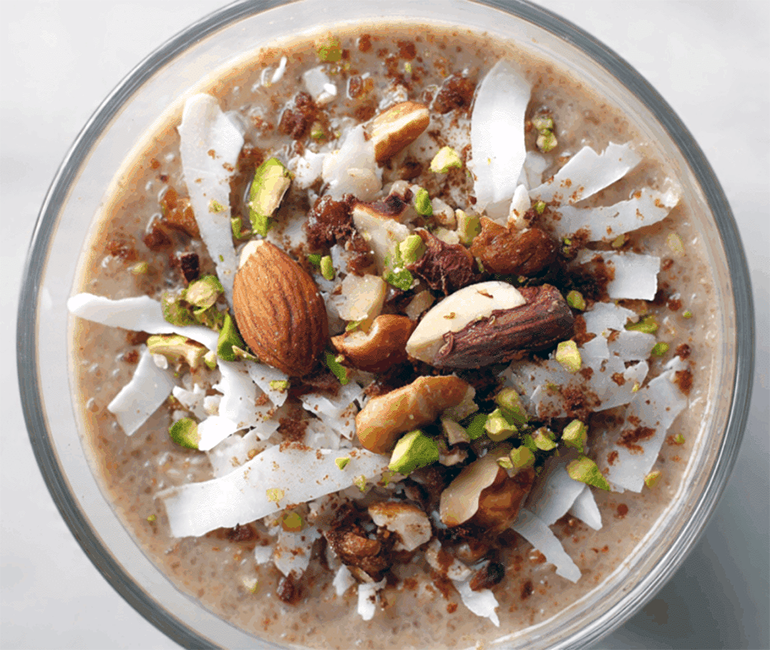 meghli, rice flour pudding served in a glass and topped with shredded coconut and nuts