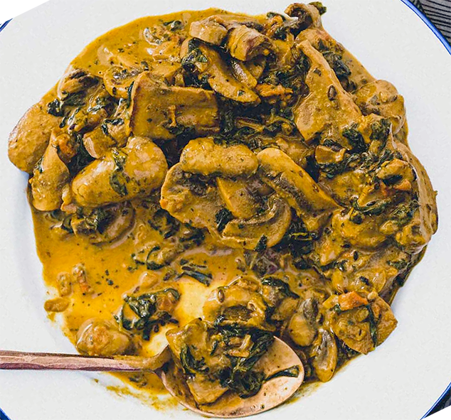 mushroom and methi (fenugreek) curry served in a white dish