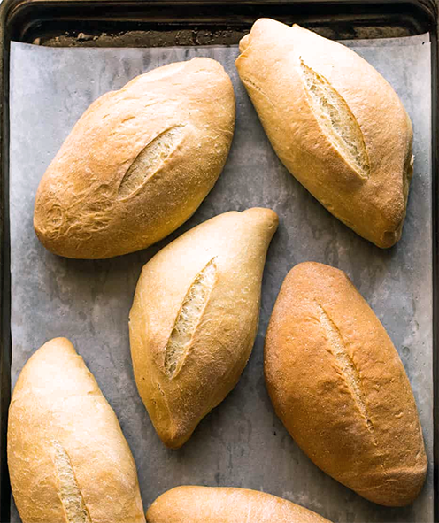 Mexican bolillo rolls on a baking tray
