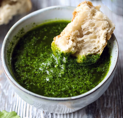 canaries mojo verde herb sauce in a bowl with a hunk of bread