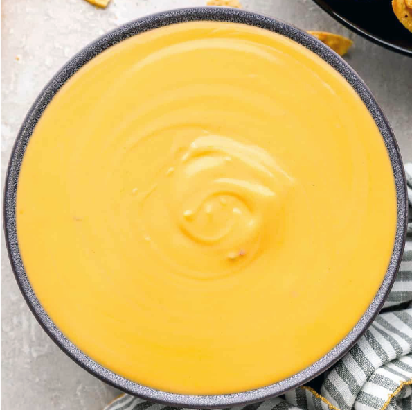 the classic cheese sauce for drizzling on nachos shown in a bowl