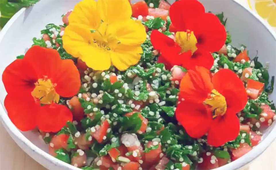 fresh tabbouleh garnished with nasturtium greens and nasturtium flowers in a bowl