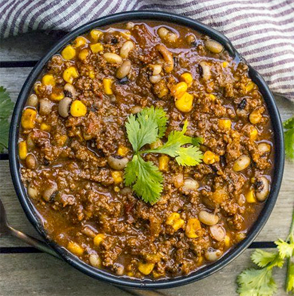 stew of white beans, beef and sweetcorn served in an oil, onion and mustard sauce in a bowl