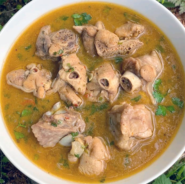 Nigerian spiced chicken pepper soup served in a white bowl