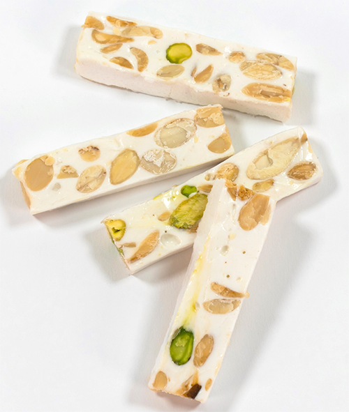 sticks of nut-containing montelimar nougat against a white background