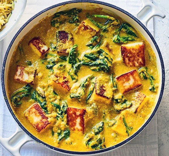 paneer and sweet potato korma with spinach in a casserole dish