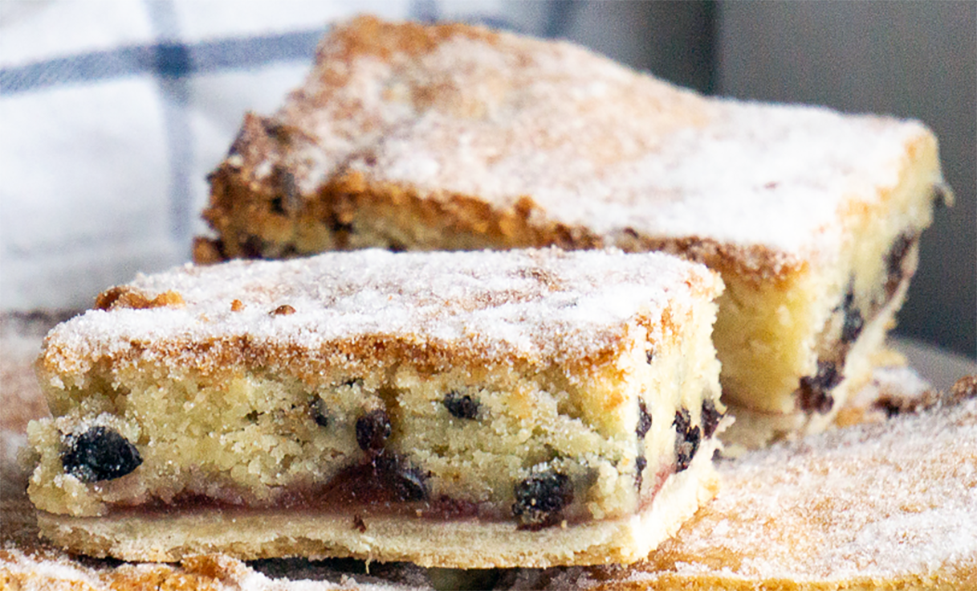 two slices of curranty paradise slice on top of the remaining cake