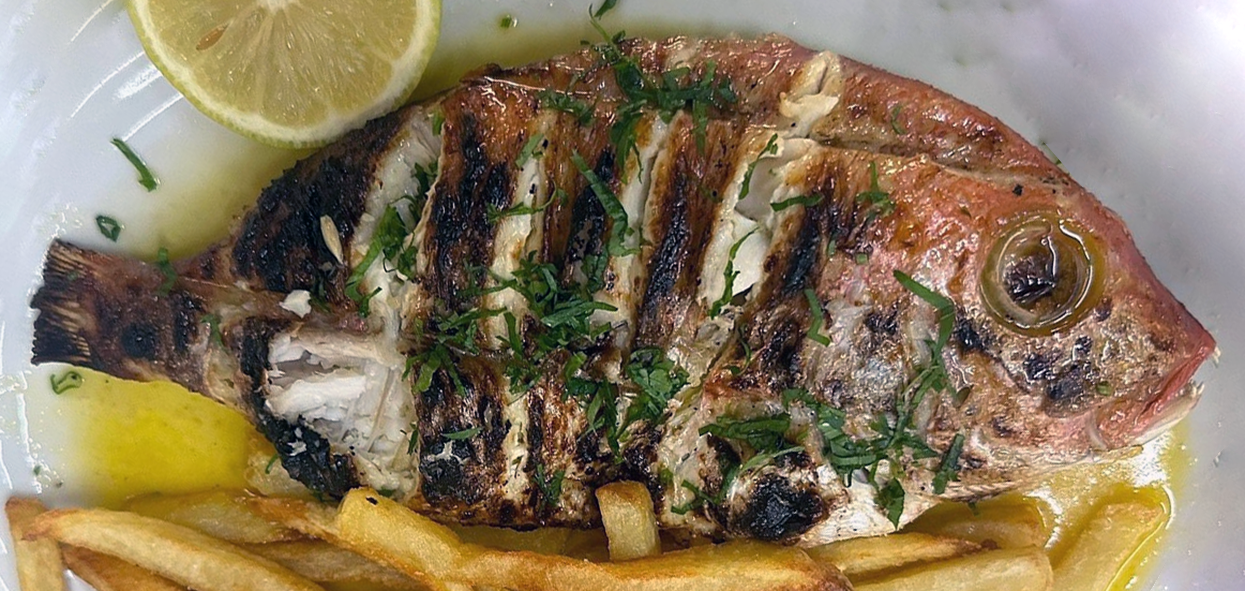 fish barbecued with piri-piri chillies served topped with shredded flat-leaf parsley and chips