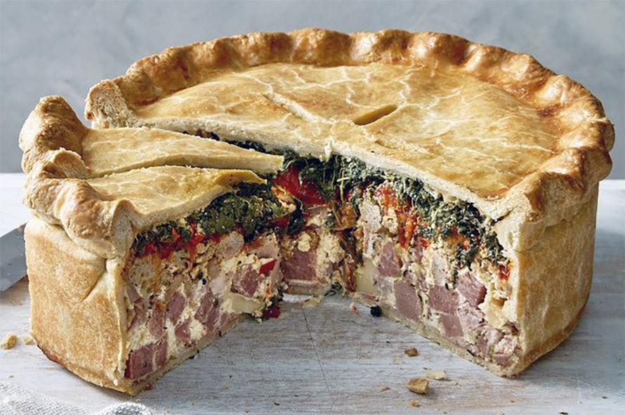 Italian pizza rustica, a pice with a sausage, egg and vegetable filling with a wedge removed to show the filling