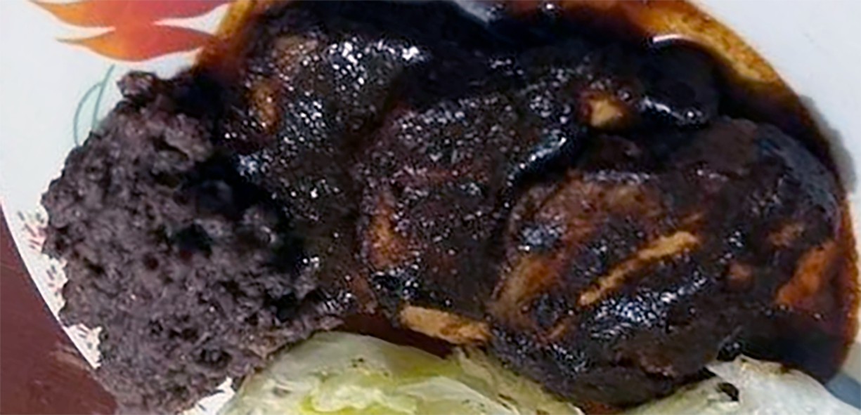 slices of pork fillet (tenderloin) covered in chocolatey adobo sauce served with refried beans