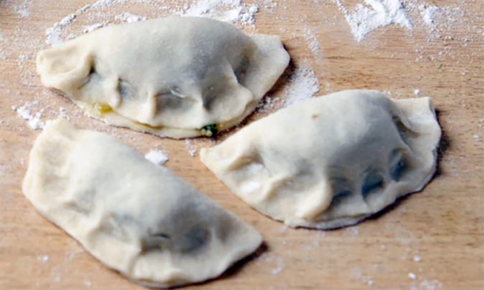 three dumplings prepared on a wooden work surface