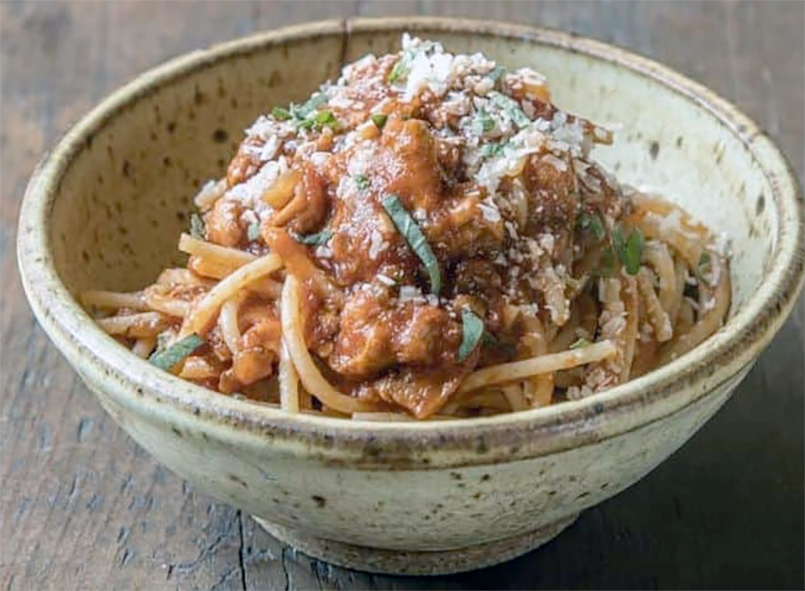 puffball ragú served with spaghetti topped with grated parmesan cheese served in a bowl