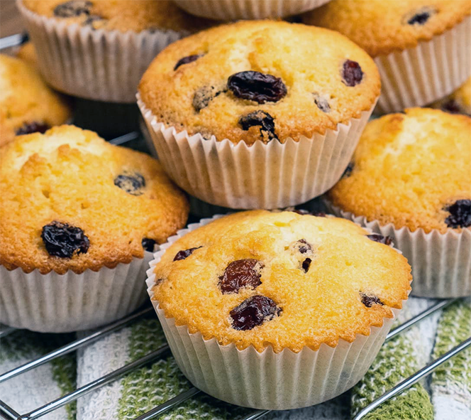pile of cupcakes containing raisins plumped in rooibos on a cooling rack