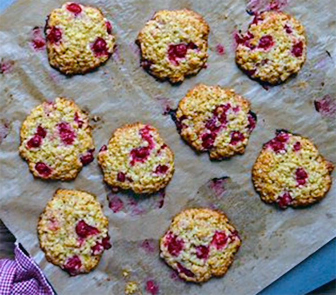 baked redcurrant and oat biscuits arranged on a sheet of greaseproof paper