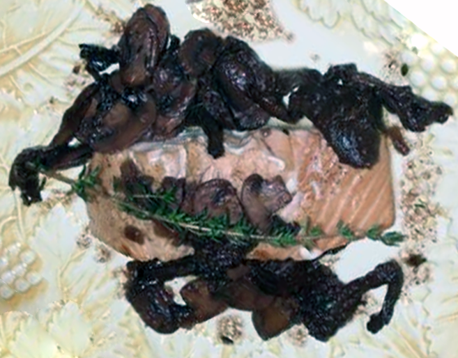 Grilled salmon served on a plate with mushrooms in a red wine sauce garnished with a sprig of thyme
