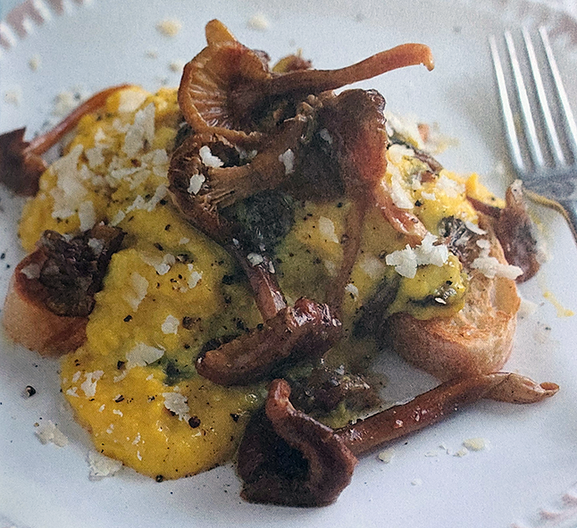 Chanterelles cooked with scrambled eggs served on two pieces of toast