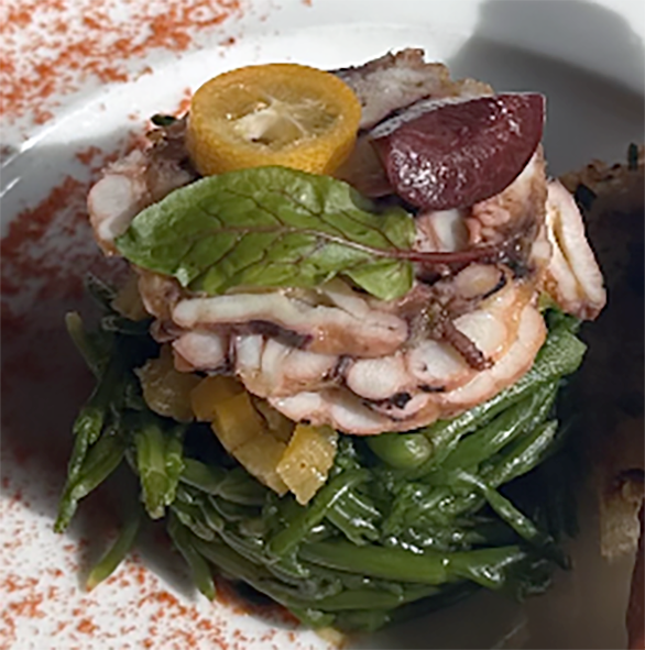 blanched marsh samphire arranged on a plate topped with sliced slow-cooked octopus and a vinagred fruit salad