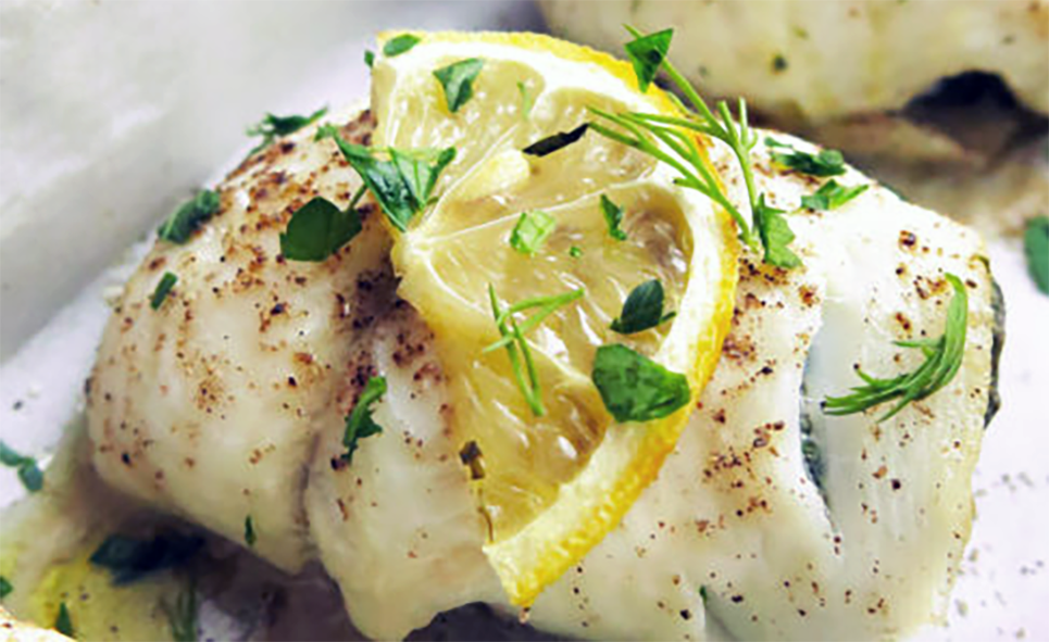 Sole fillet with a mushroom and ricotta filling served on a plate with a slice of lemon