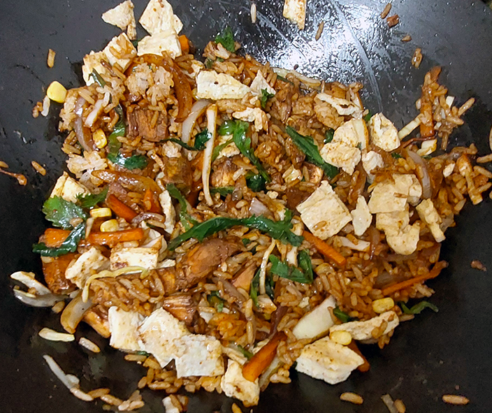 special fried rice with oxeye daisy greens cooking in a wok