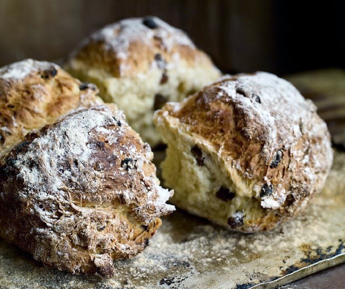 four spotted dog fruited sodabread buns on a floured work surface</a>