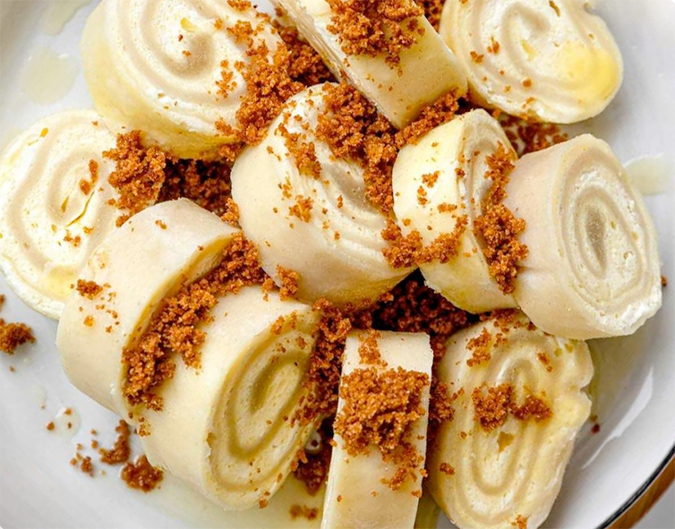 slices of steamed struklji qith quark filling on a plate garnished with toasted breadcrumbs