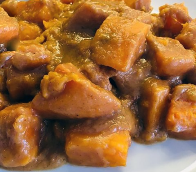sweet potato wedges in a peanut sauce served on a white plate