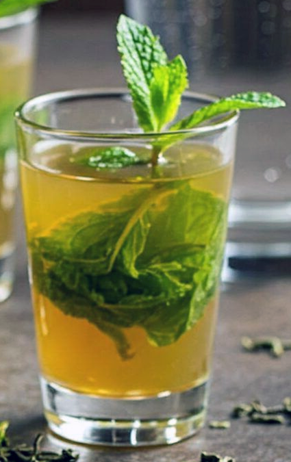 mint tea in a tall glass garnished with a generous sprig of mint