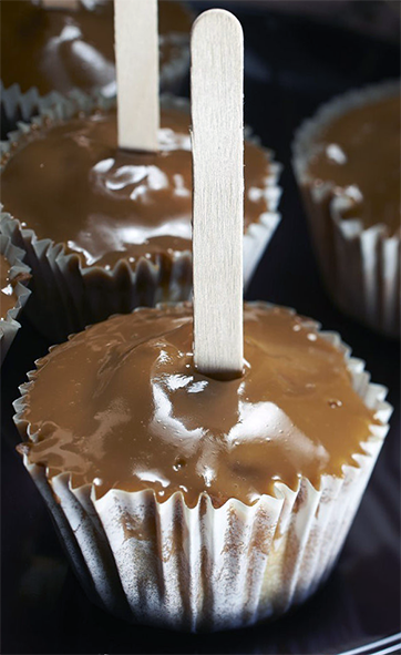 toffee apple cupcake with toffee icing and a lollipop stick