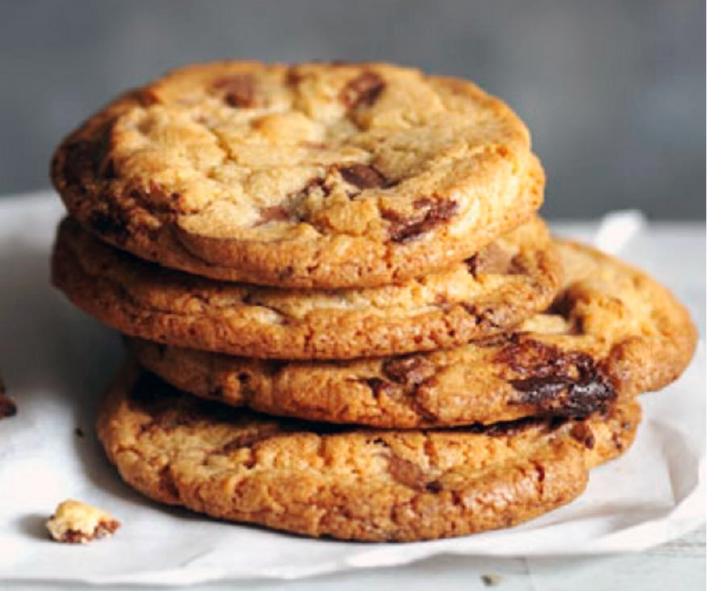 four chocolate chip biscuits piled on a cloth
