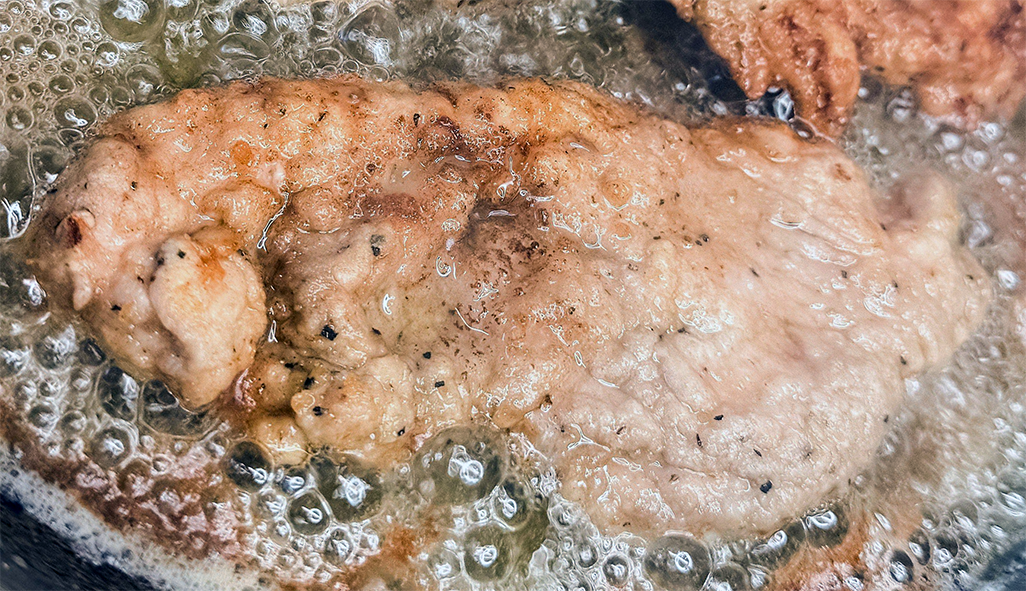 turkey piccata cooking in a frying pan