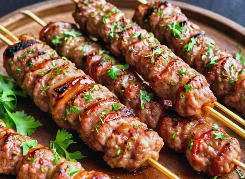 turkmen kebaps on a wooden chopping board garnished with coriander leaves
