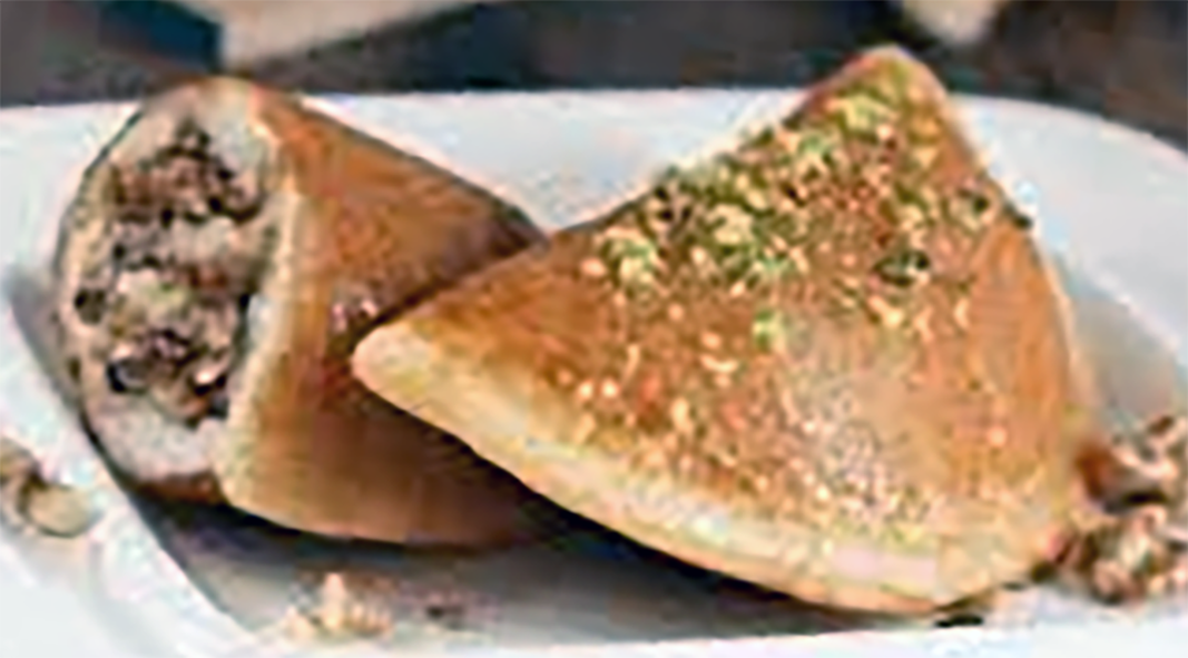 yeasted pancakes stuffed with a mix of sugar, walnuts and orange flower water on a plate with one split open to reveal the filling