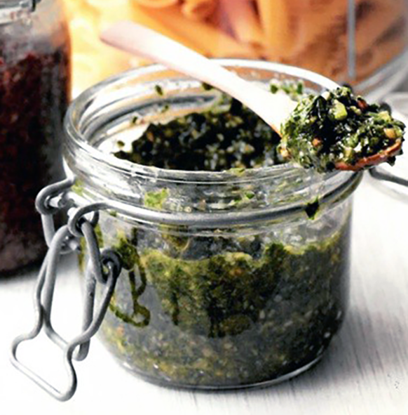 wild water mint pesto in a clip top jar with a portion on a wooden spoon