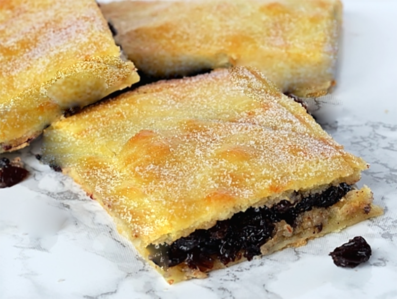 pastry squares with a spiced currant filling with one end cut to reveal the filling