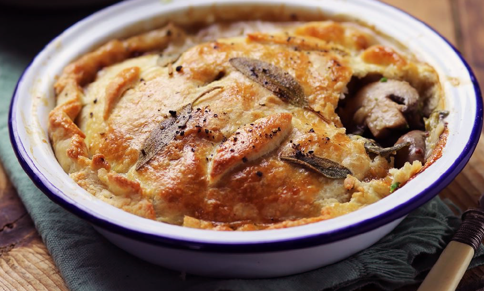 wild mushroom and leek bakee with cheese topping baked in a glazed metal dish